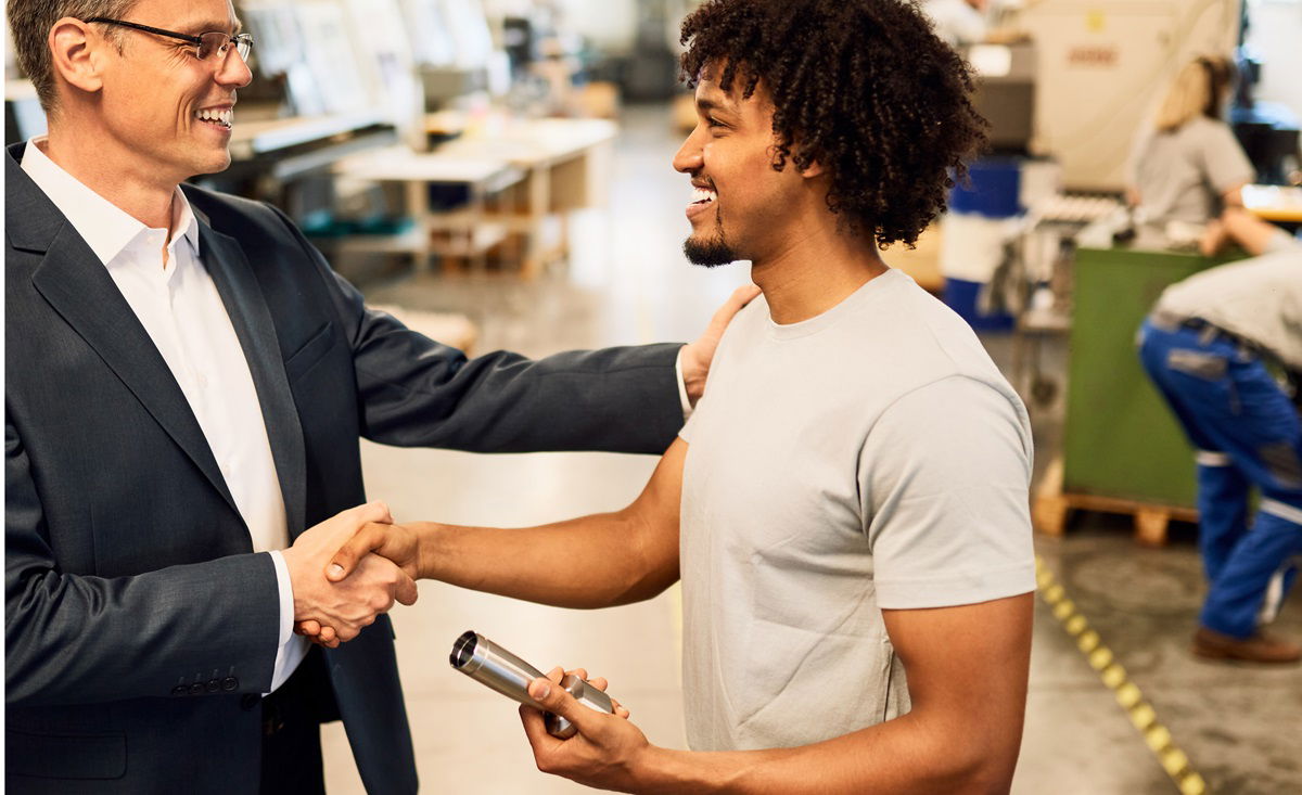 Employer shakes hands with skilled worker.