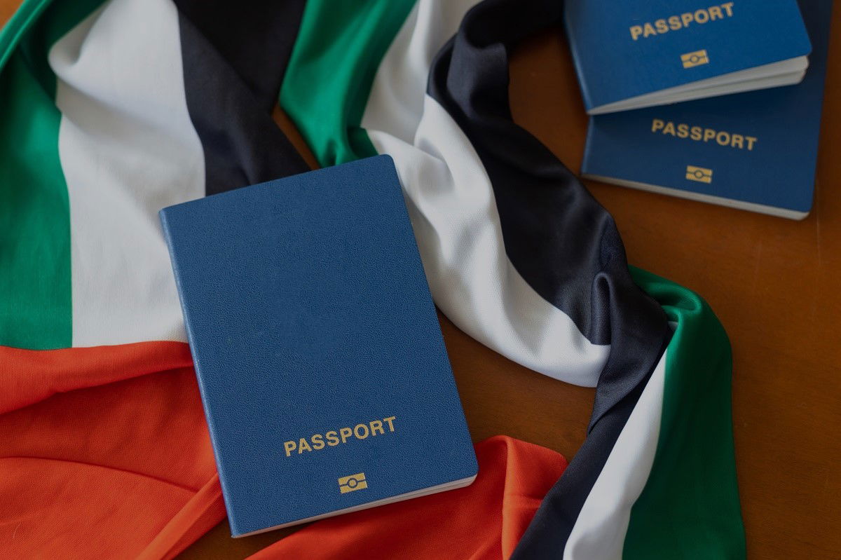 Reisepass liegt auf Flagge der Vereinigten Arabischen Emirate