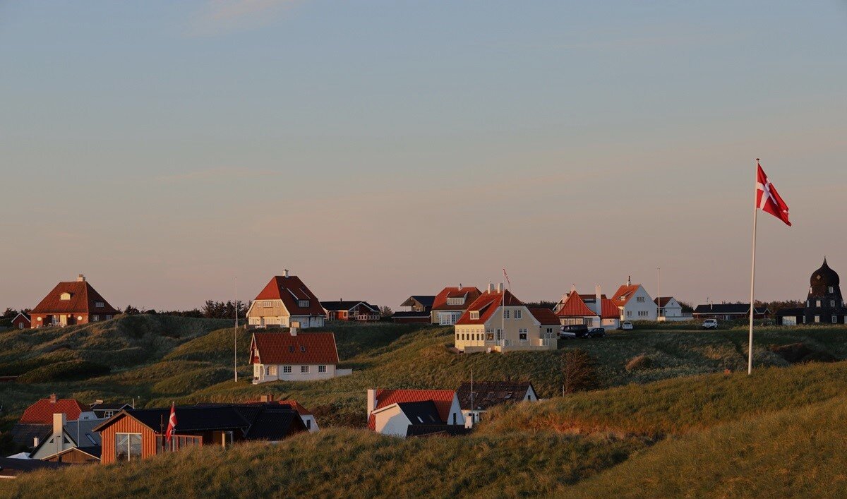 Houses standing on hills with the Danish flag