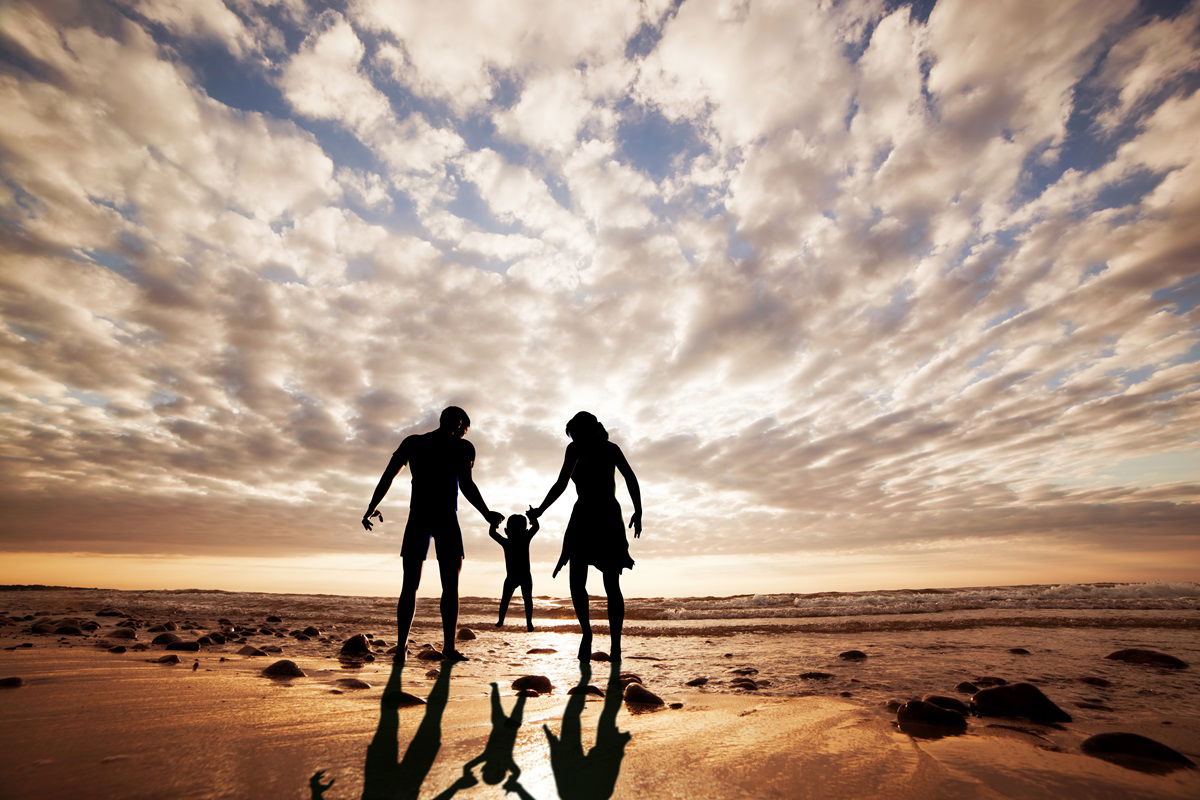 Family walking at the beach at sunset