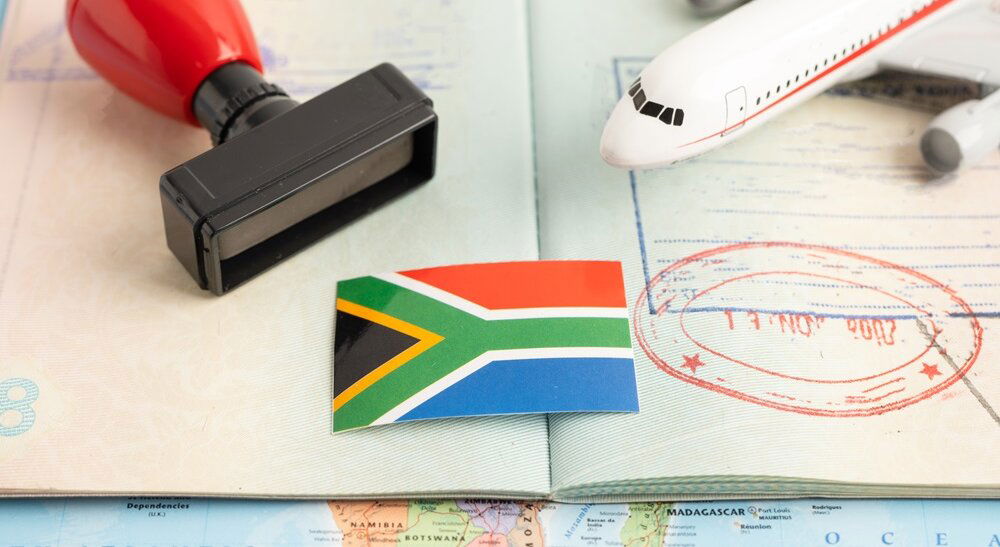 Passport mit Stamp, South African flag and toy plane
