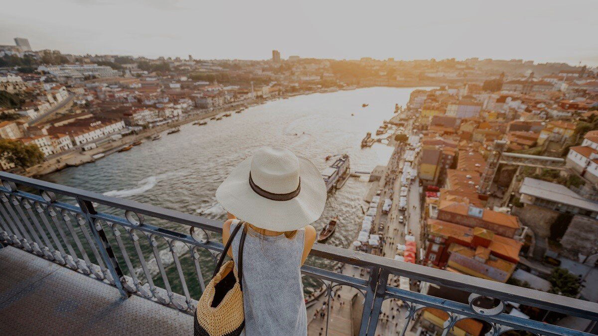 Leben in Portugal: Frau steht auf einer Brücke mit Blick auf Porto