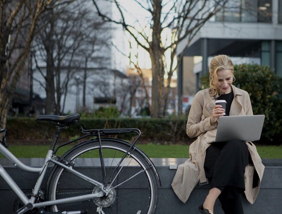Woman sitting on a bench working in Denmark at her laptop