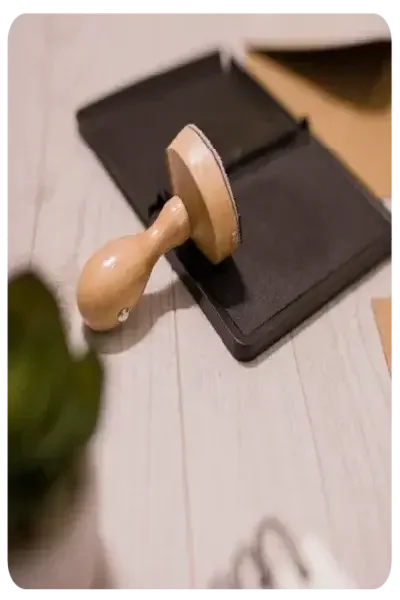 Una almohadilla de tinta abierta que incluye sellos yace sobre una mesa.