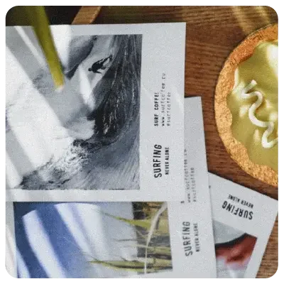 Several white surfing brochures are lying on a dark brown wooden table, viewed from above.