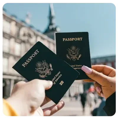 Two green passports are held centrally in the picture by a man and a woman.