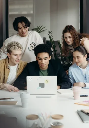People sitting around a laptop 