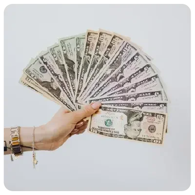 One hand holds numerous banknotes spread out in a fan shape in the picture.