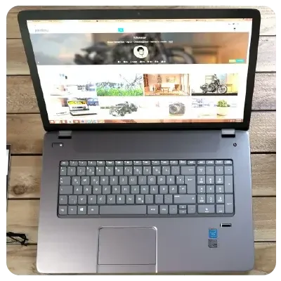 Blick auf einen aufgeklappten Laptop, der viele Bilder einer Homepage zeigt.