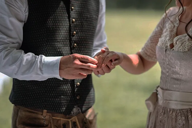 Man putting ring on woman's finger