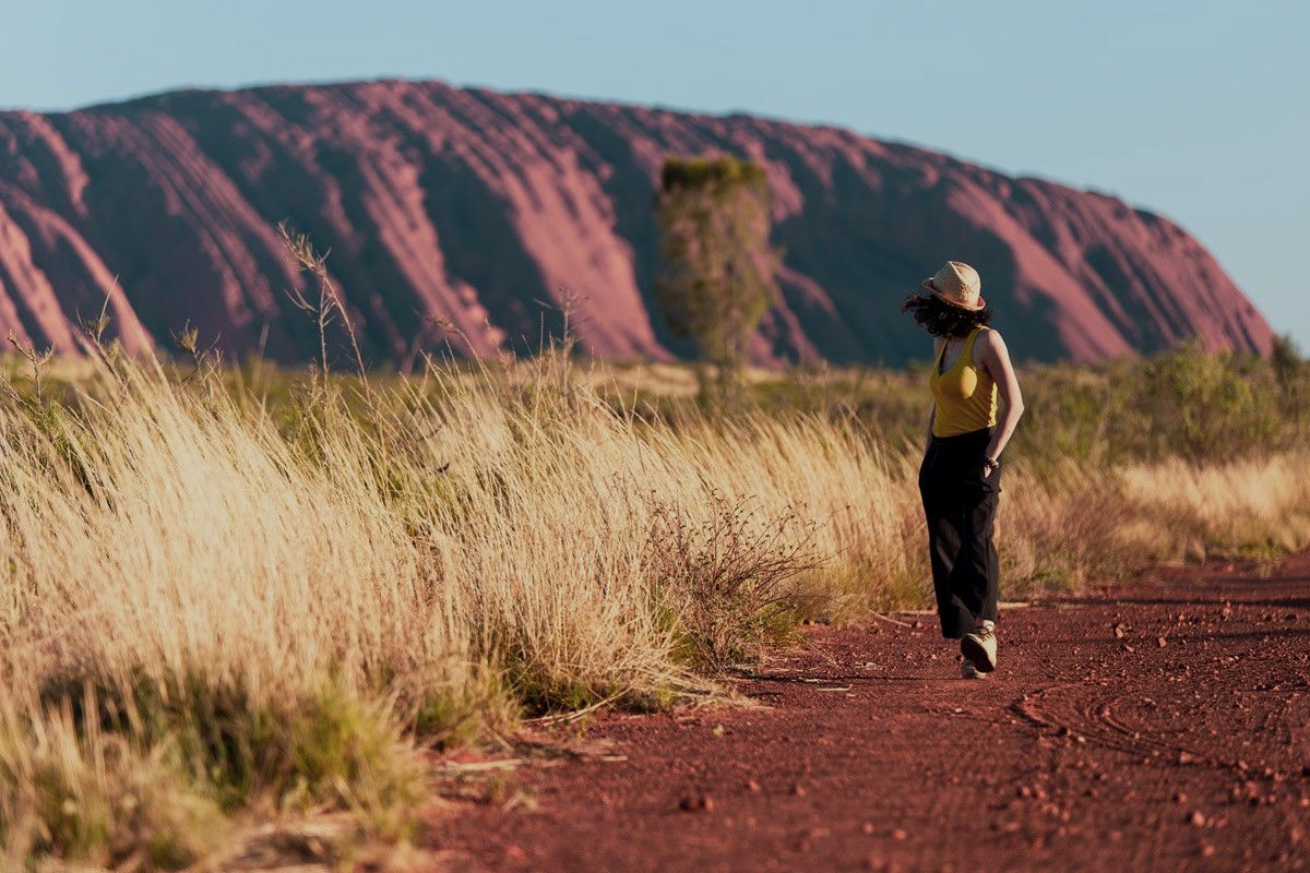 Frau steht am Uluru in Australien