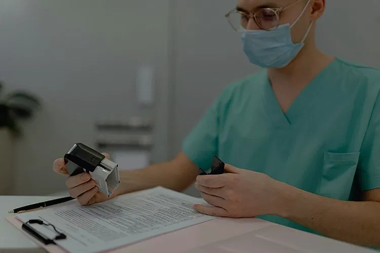 Person in a hospital putting a stamp on a document