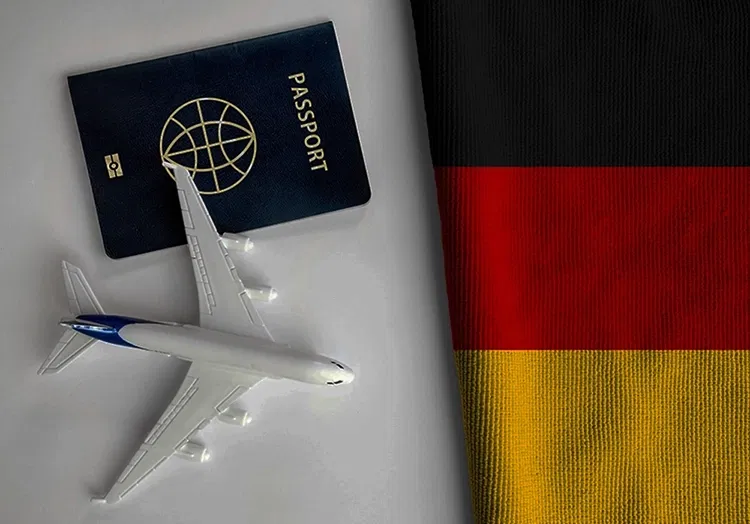 Model plain, passport and German flag on a table