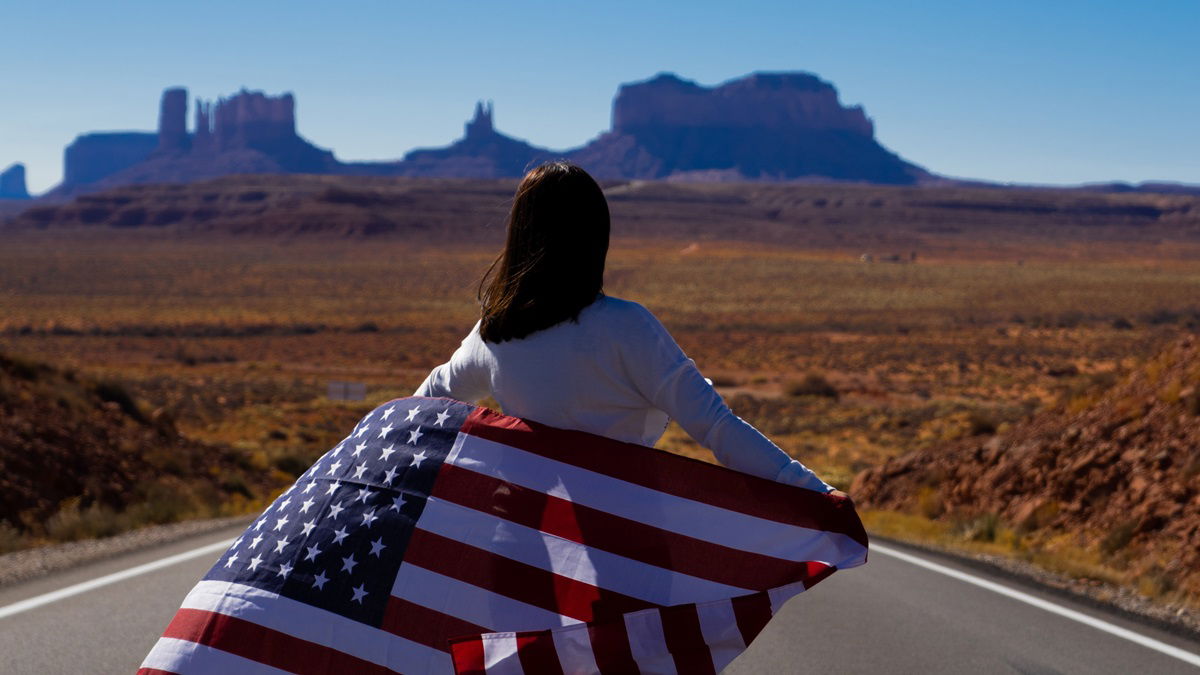 Woman standing on a highway with US flag