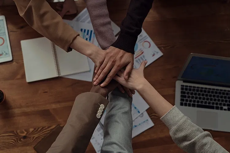 A group of people putting their hands together