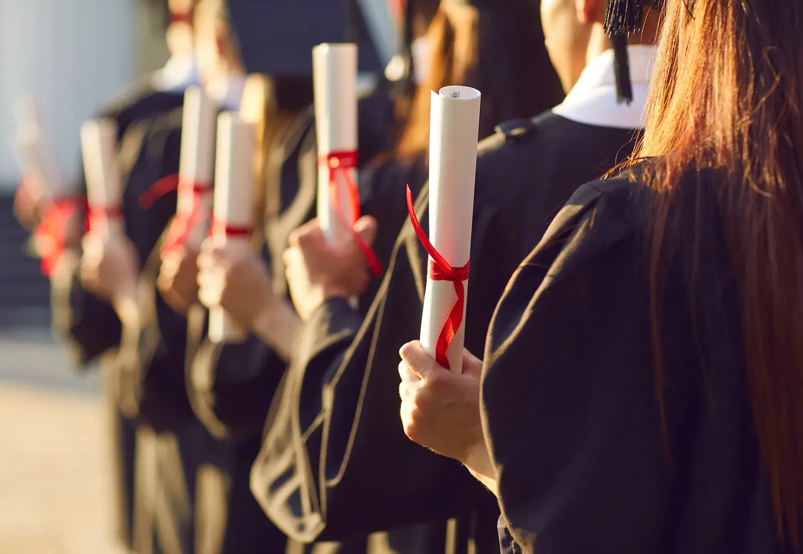 Studenten halten ihr Abschlusszeugnis in der Hand