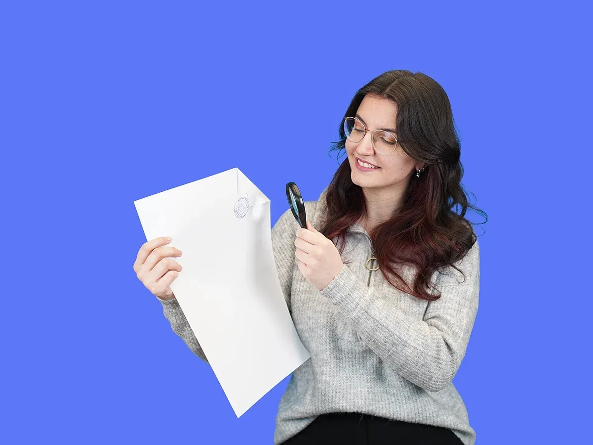 Woman holding a certified translation and looking at it with a magnifying glass