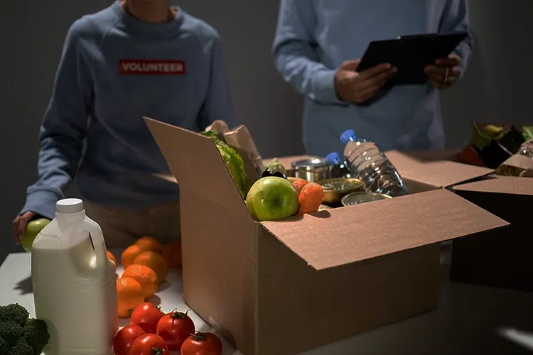 Zwei Personen stehen vor Kartons mit Essen