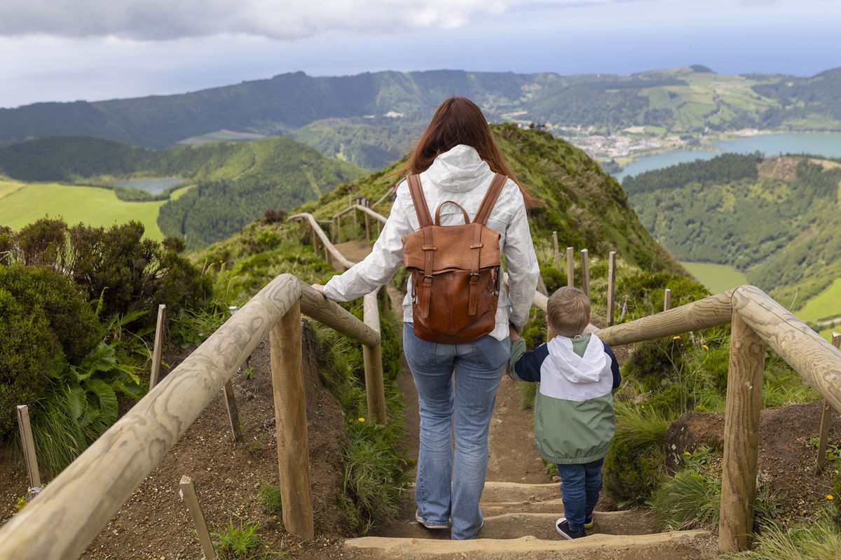 Woman with child walking down steps in picturesque landscape