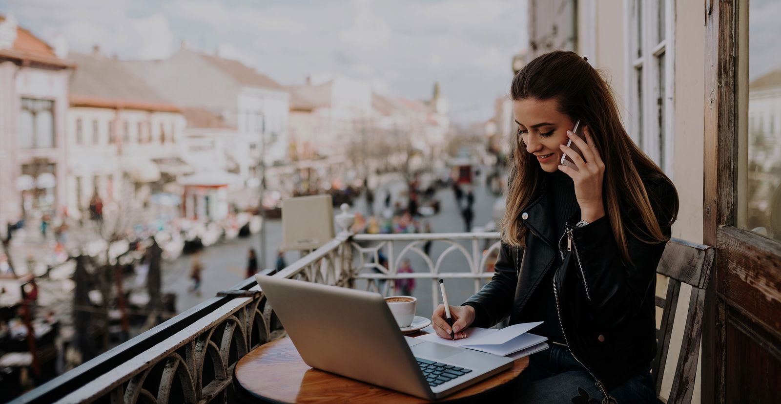 Frau auf dem Balkon am Laptop 