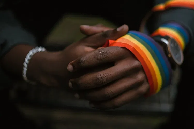 Hände mit einer Bandage in Regenbogenfarben