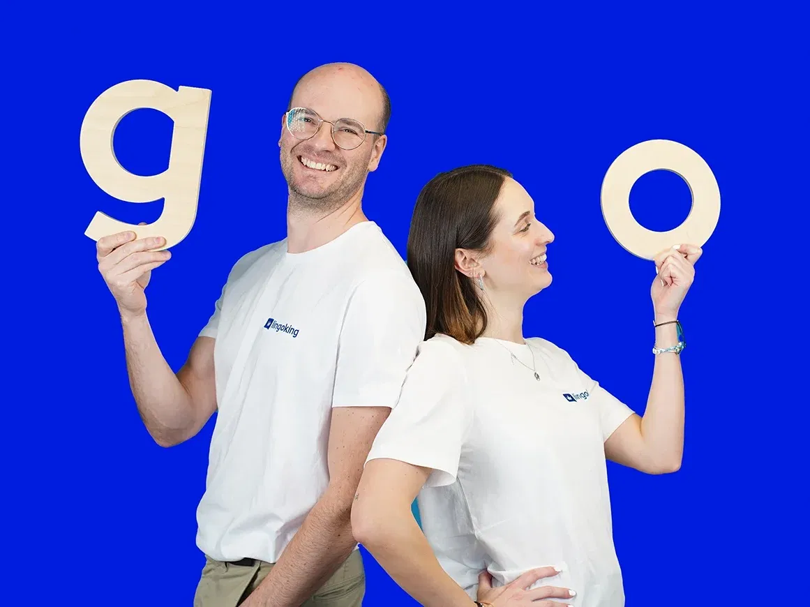 Zwei lingoking Mitarbeiter:innen stehen Rücken an Rücken, einer hält ein "go", die andere ein "o" für "go"