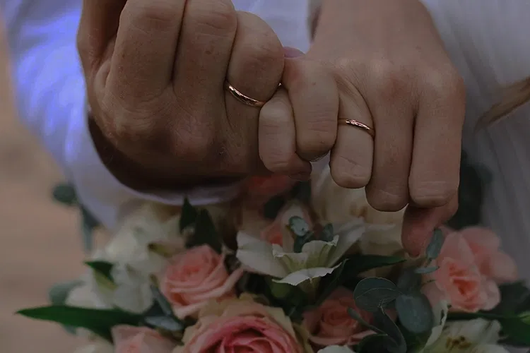 Man and woman showing their rings at a wedding