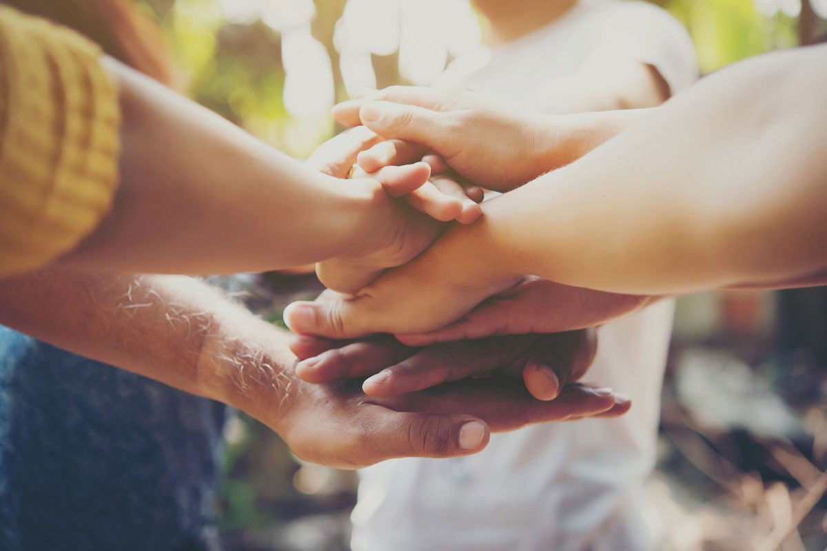 People lying their hand on each others hand