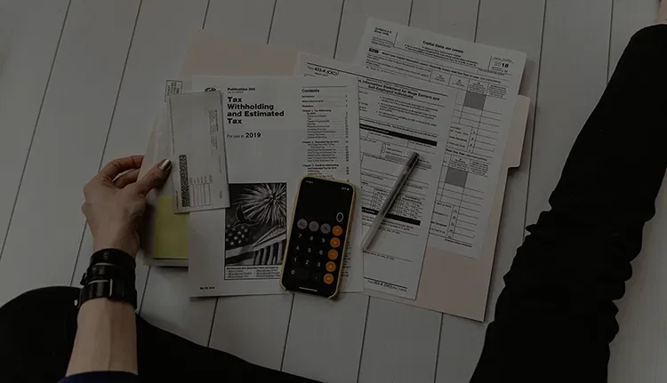Someone sitting in front of papers and a calculator