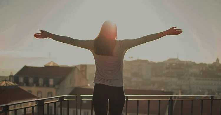 Woman extending her arms to the sun