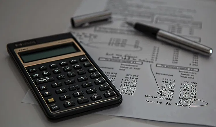 Papers with statistics and a calculator lying on a table