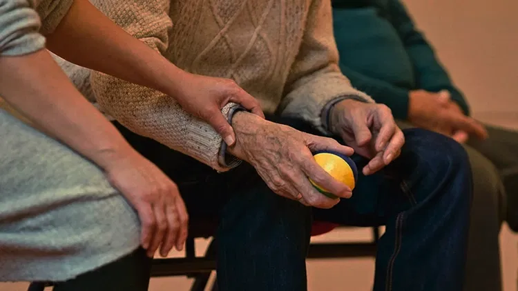 Young person holding an old person's hand