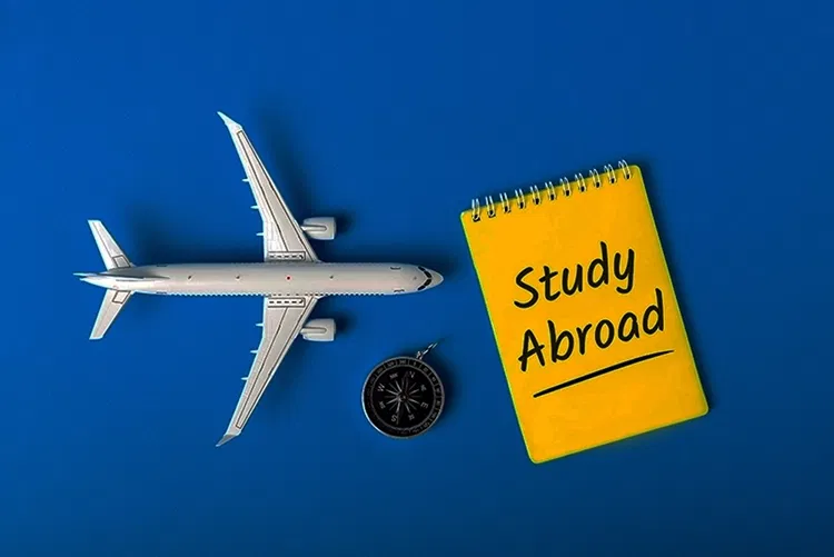 Modellflugzeug, Kompass und Block auf dem "study abroad" steht