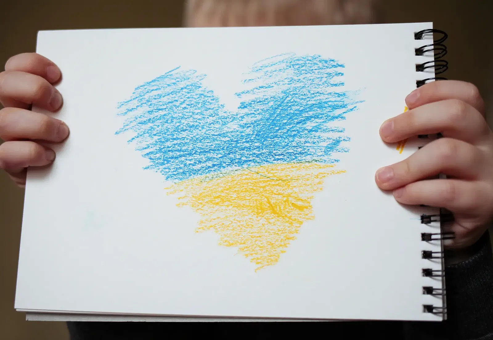 Ukrainian flag painted as heart on white paper